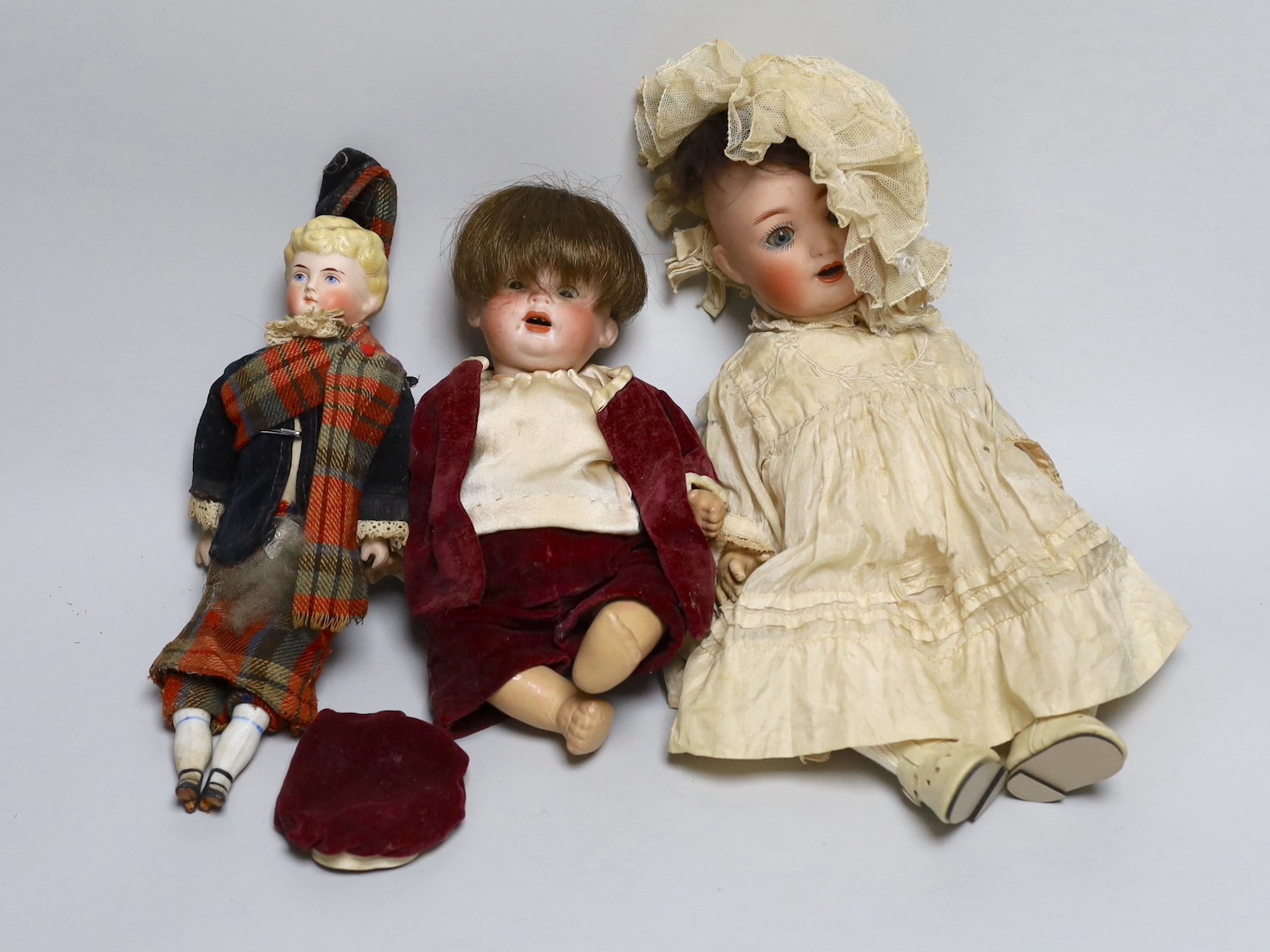 A German bent limb doll, face cracked H12in. German bent limb character baby doll H9in. bisque head Scottish doll with bisque shoes and hands H10in.